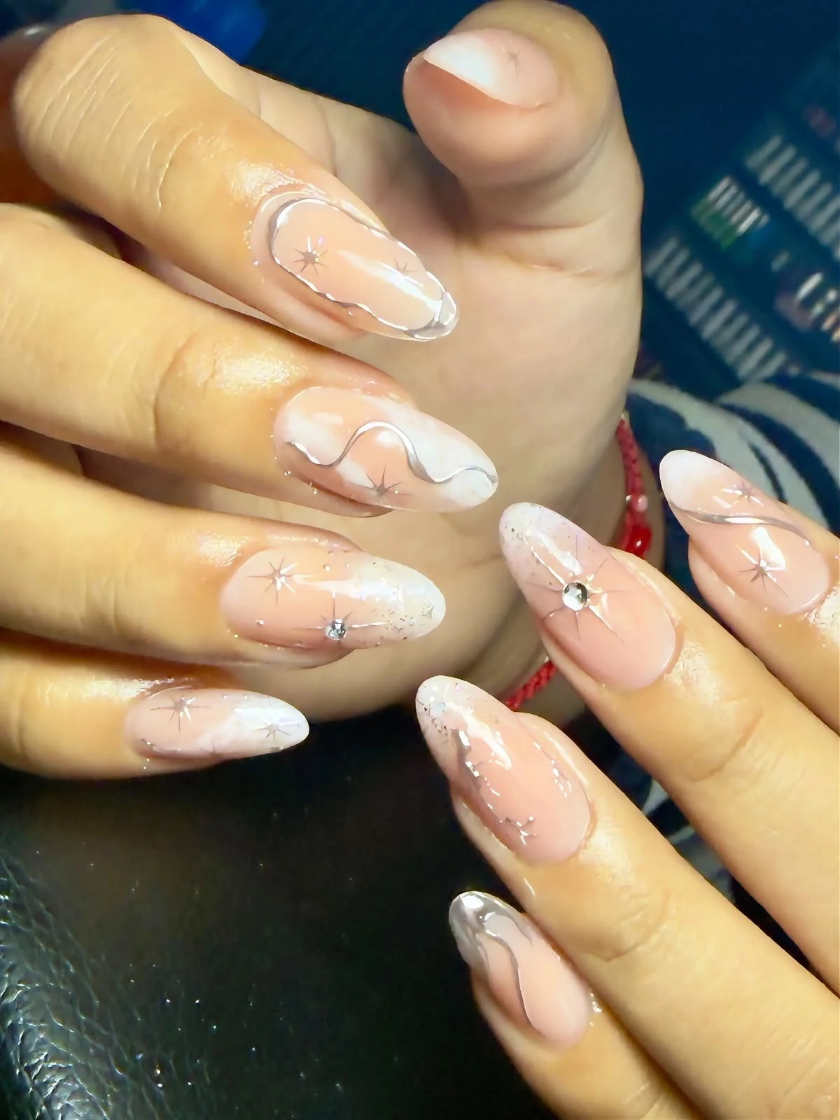Nail art nude con líneas blancas, estrellas y pedrería